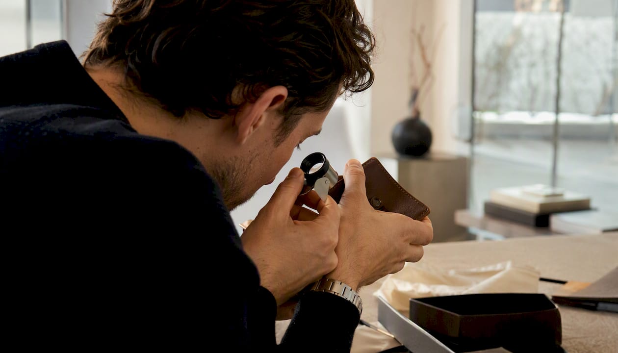 Collector examining maker's mark with loupe