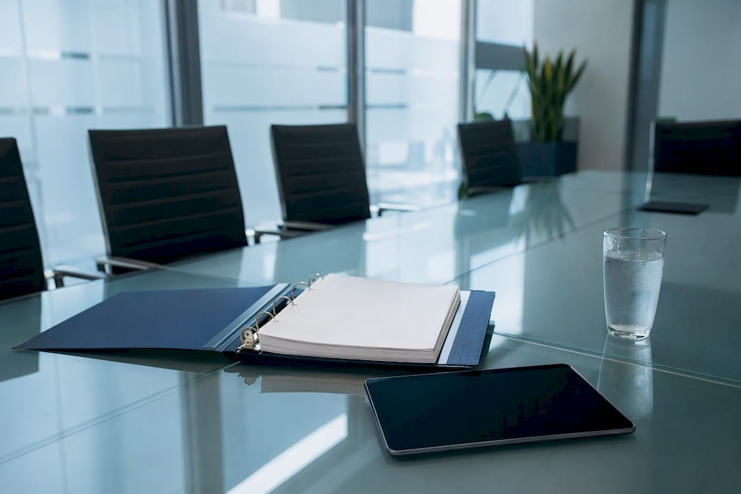 Risk governance binder and tablet on meeting table