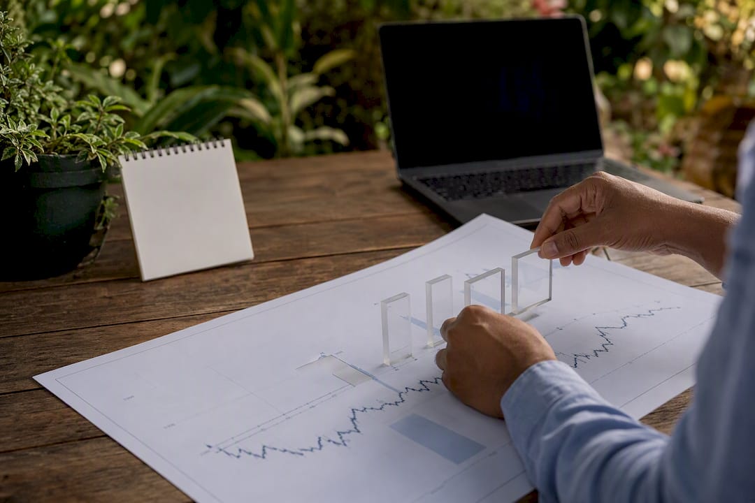 Hands placing overlays on financial chart
