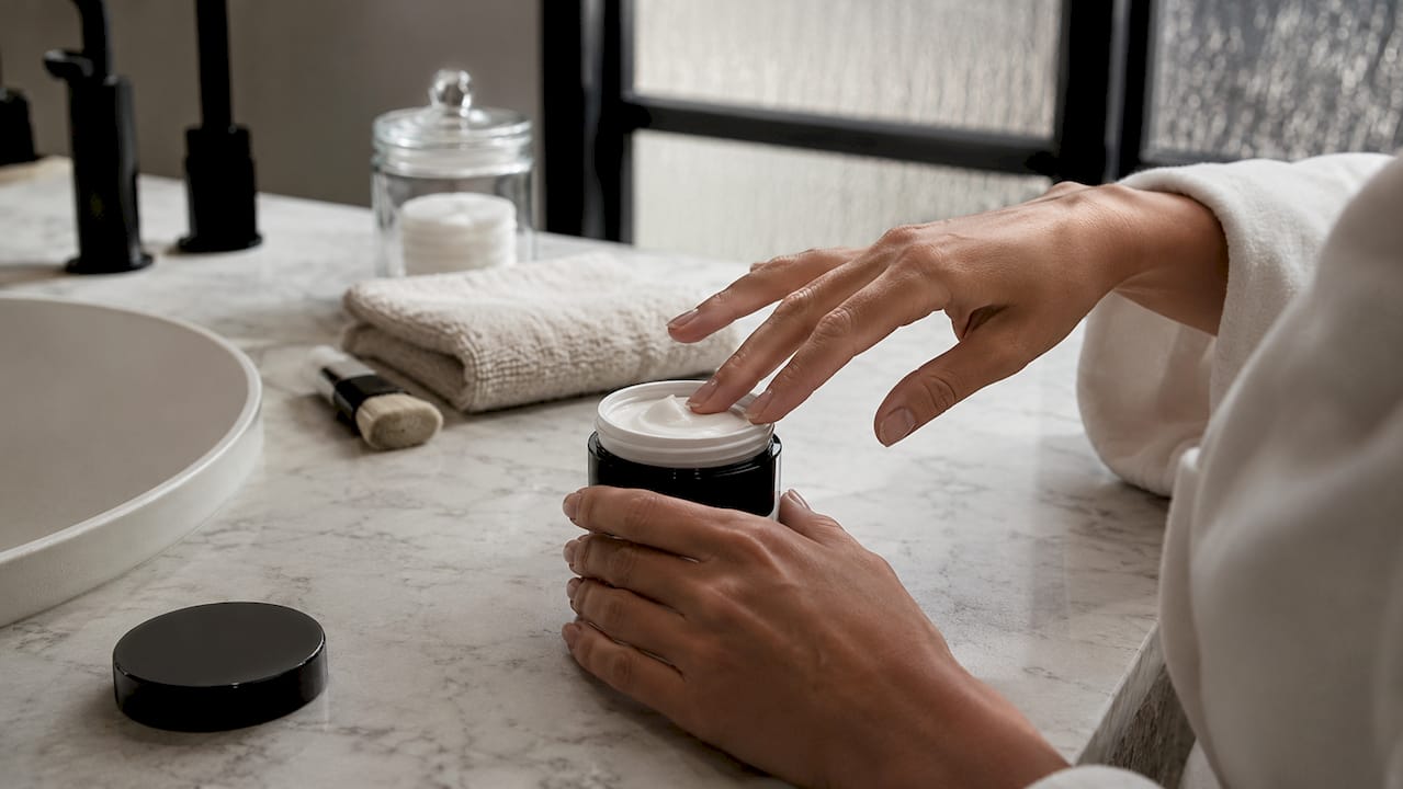 Skincare product jar on bathroom shelf
