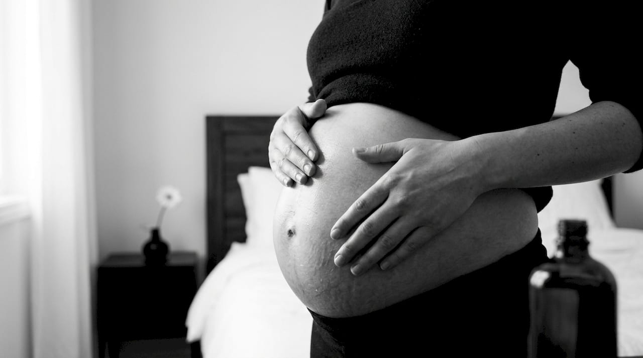 Close-up of pregnant belly being massaged with oil
