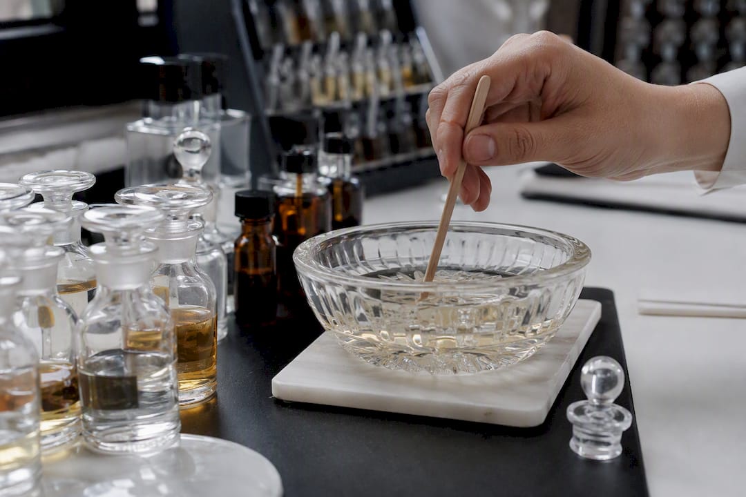 Hand mixing fragrance ingredients in glass dish