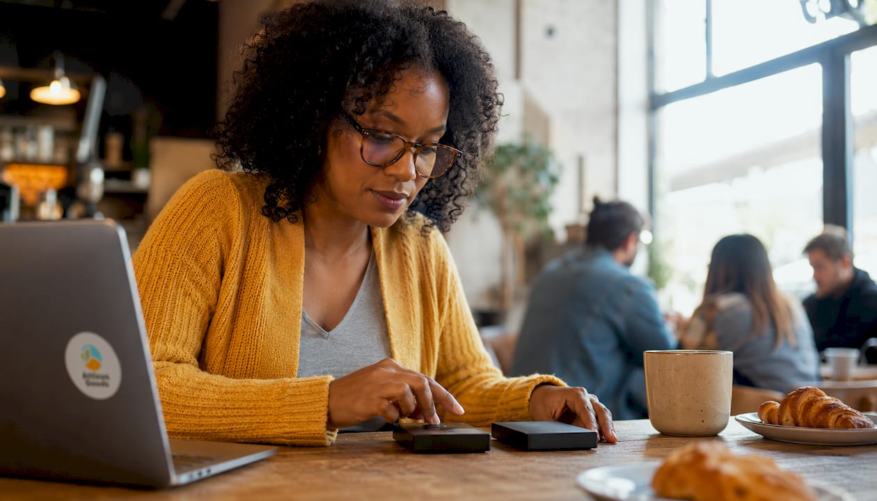 Person comparing two external hard drives at desk