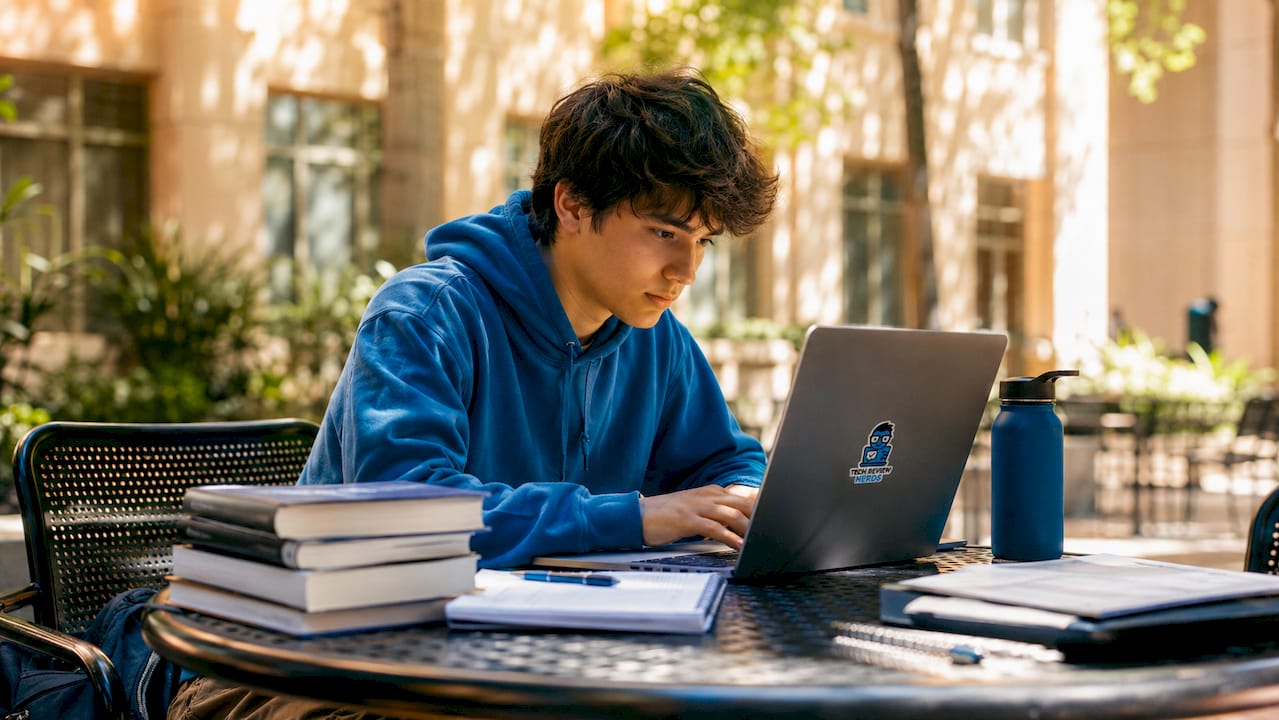 Student using laptop in library focused on multitasking