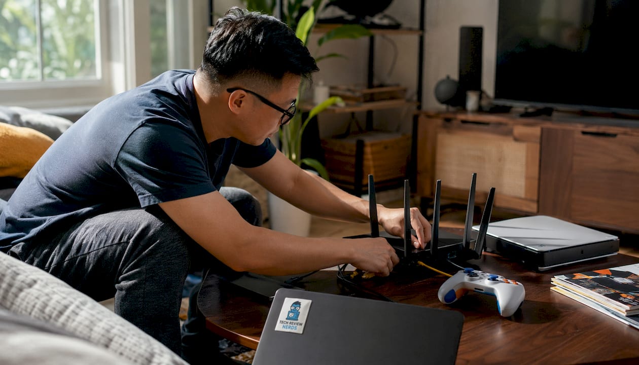 Man setting up gaming router at home desk