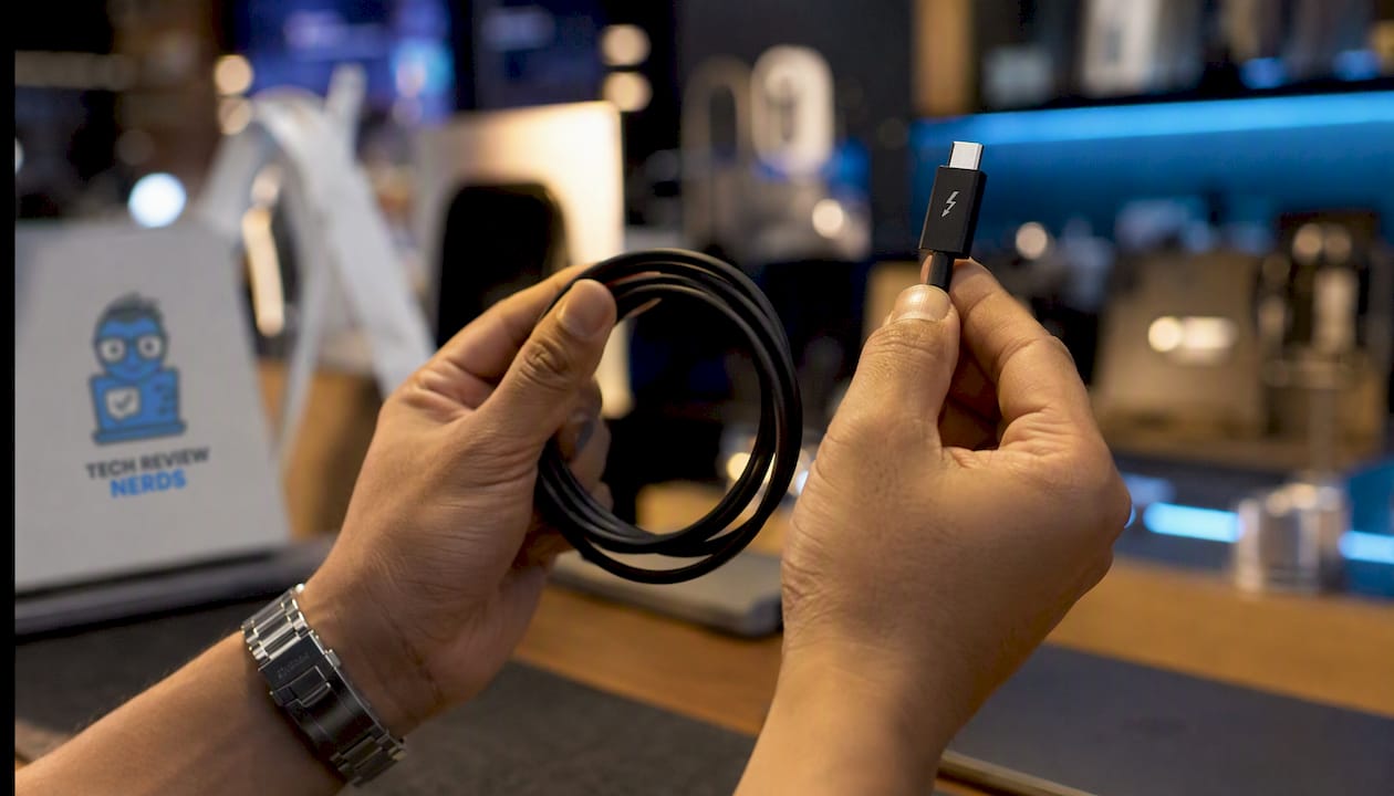 Close-up hands holding Thunderbolt cable and connector