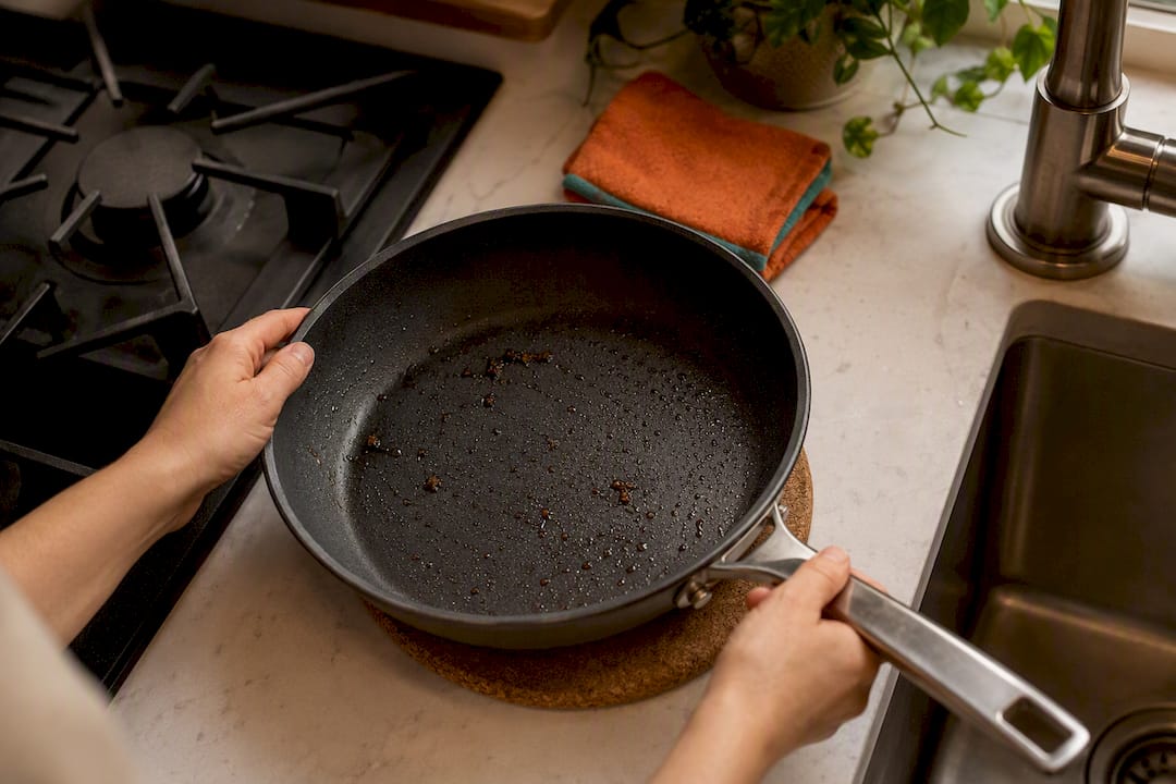 Hands cooling a pan on a trivet