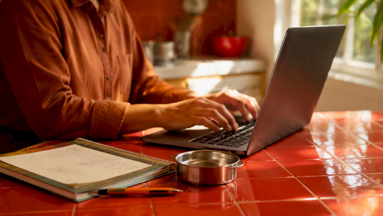 Hands typing tariff data beside steel sample