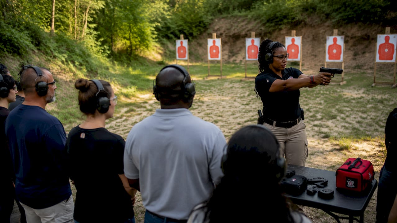 Firearms instructor teaching safe pistol handling indoors