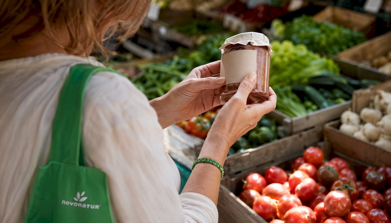 Unas manos revisan la etiqueta de los ingredientes en un producto natural.