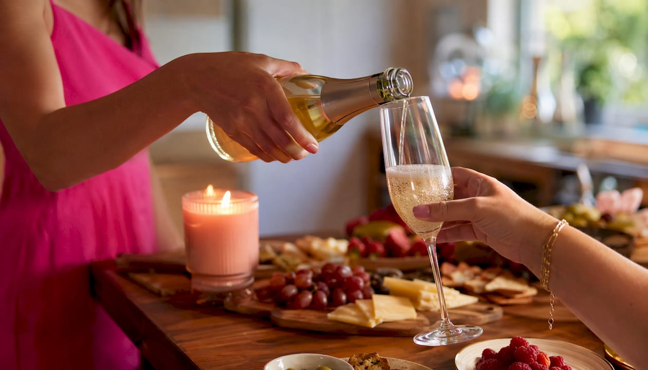 Hands pouring sparkling wine at tasting