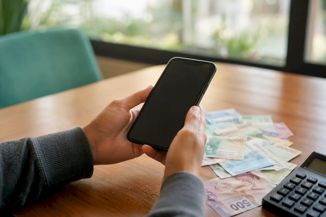 Hands with phone showing currency conversion app