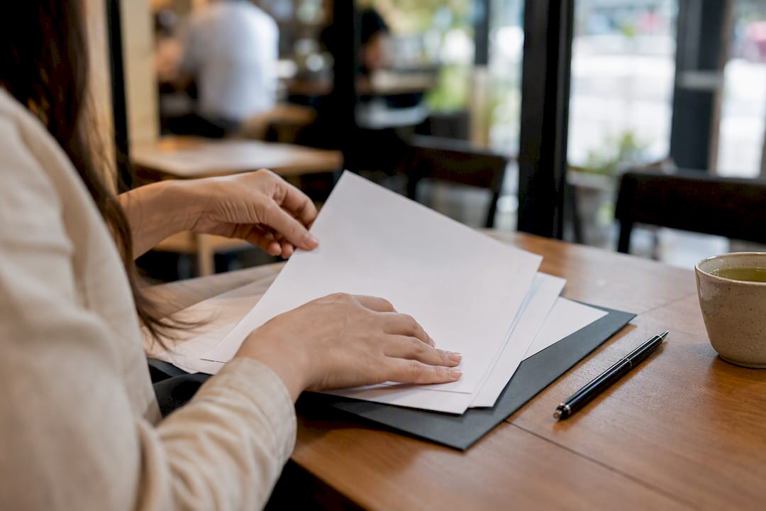 Hands completing checklist for foreign income mortgage application