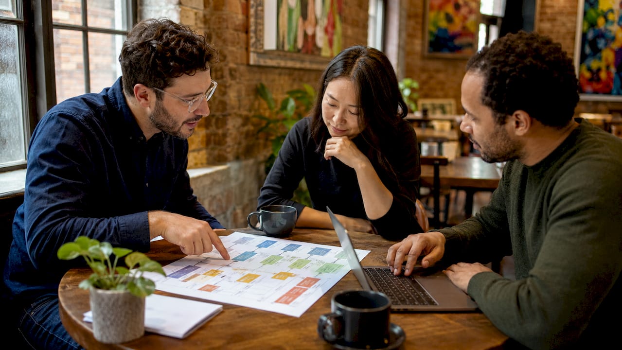 Team discussing UX research findings around table