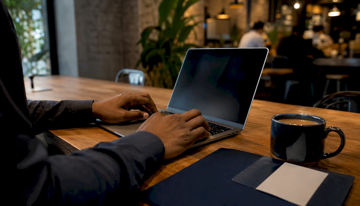 Hands typing on laptop in coworking space