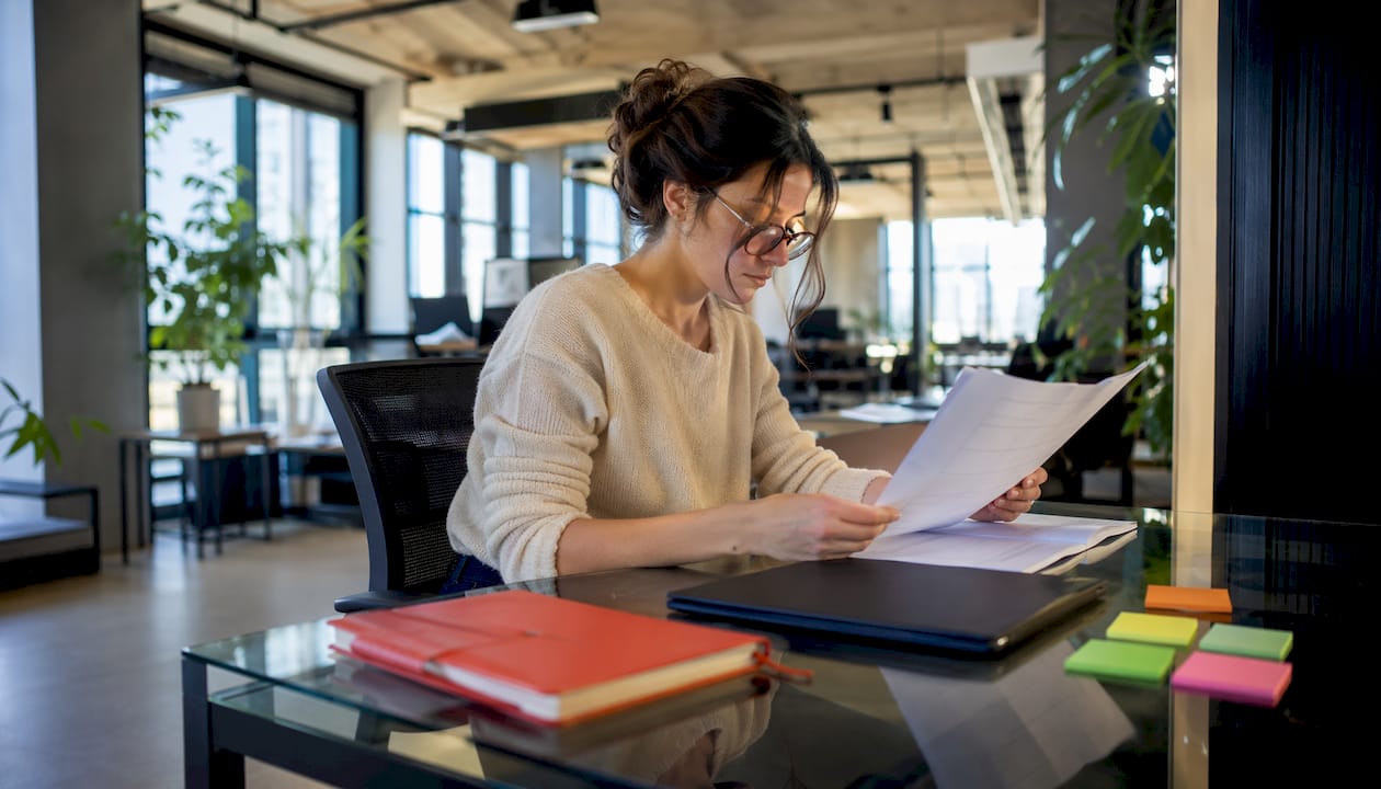 Rebrand without losing customer loyalty: a playbook 3 • MB Brand Communications Project manager reviewing phased rollout documents