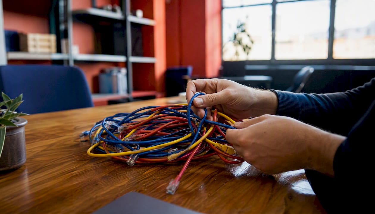 Hands untangling data cables