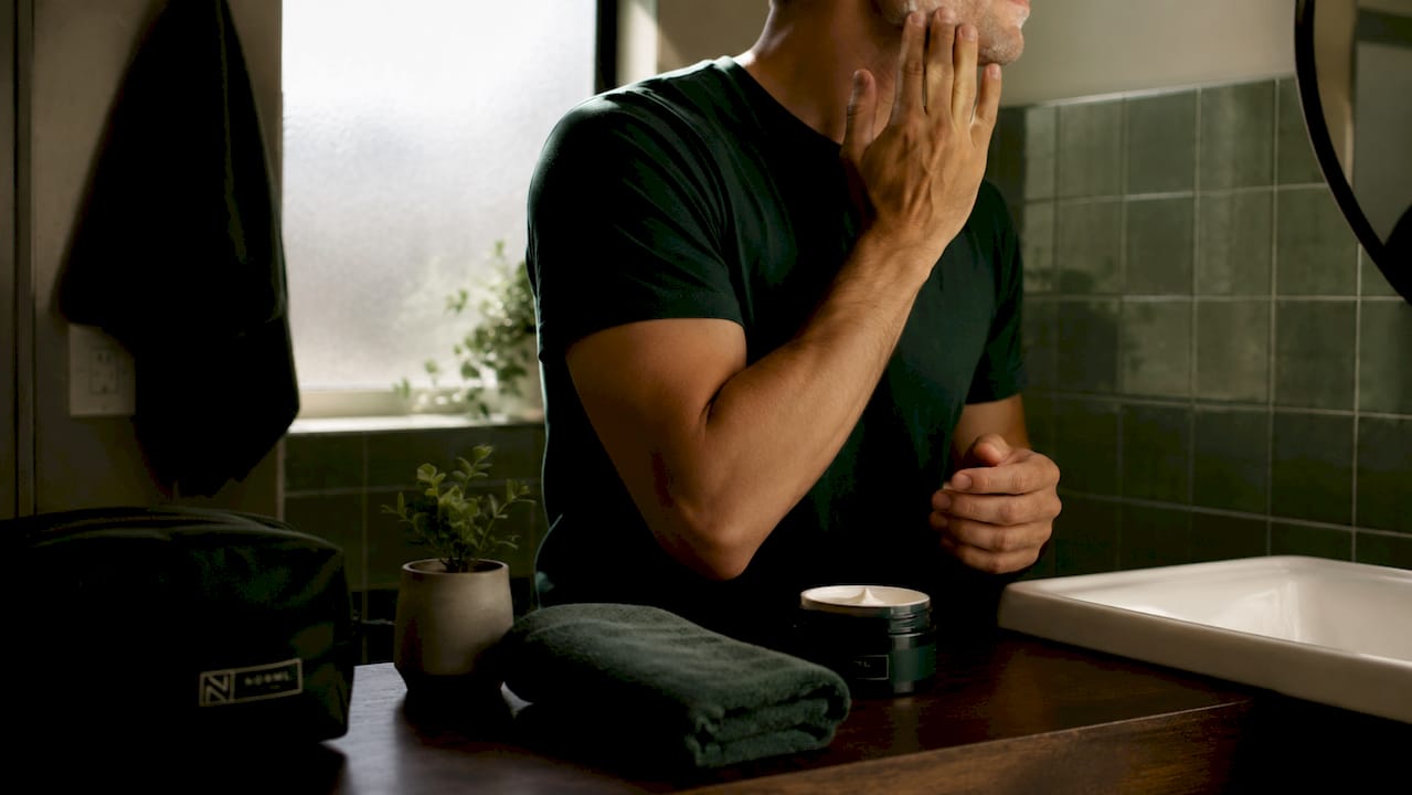 Hands applying moisturizer on freshly shaved face
