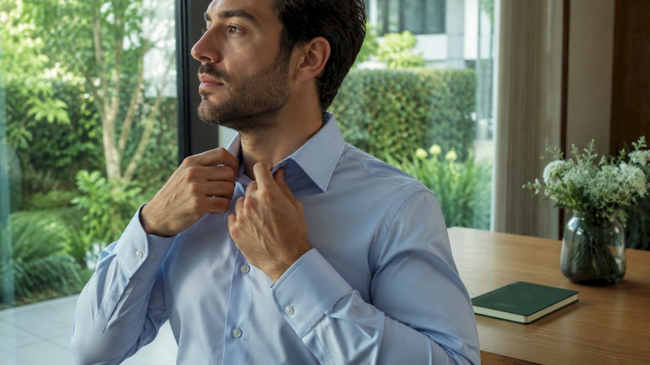 Man adjusting shirt collar as posture reminder