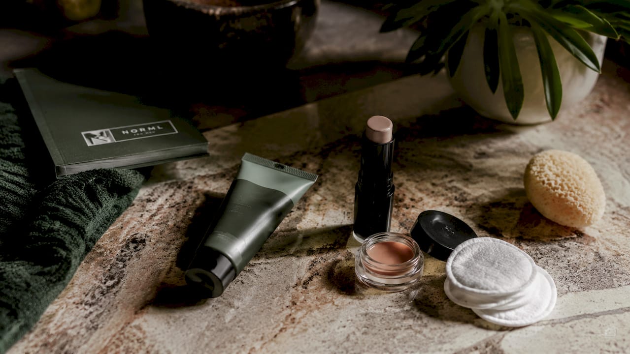 Flatlay of men’s concealer and grooming tools
