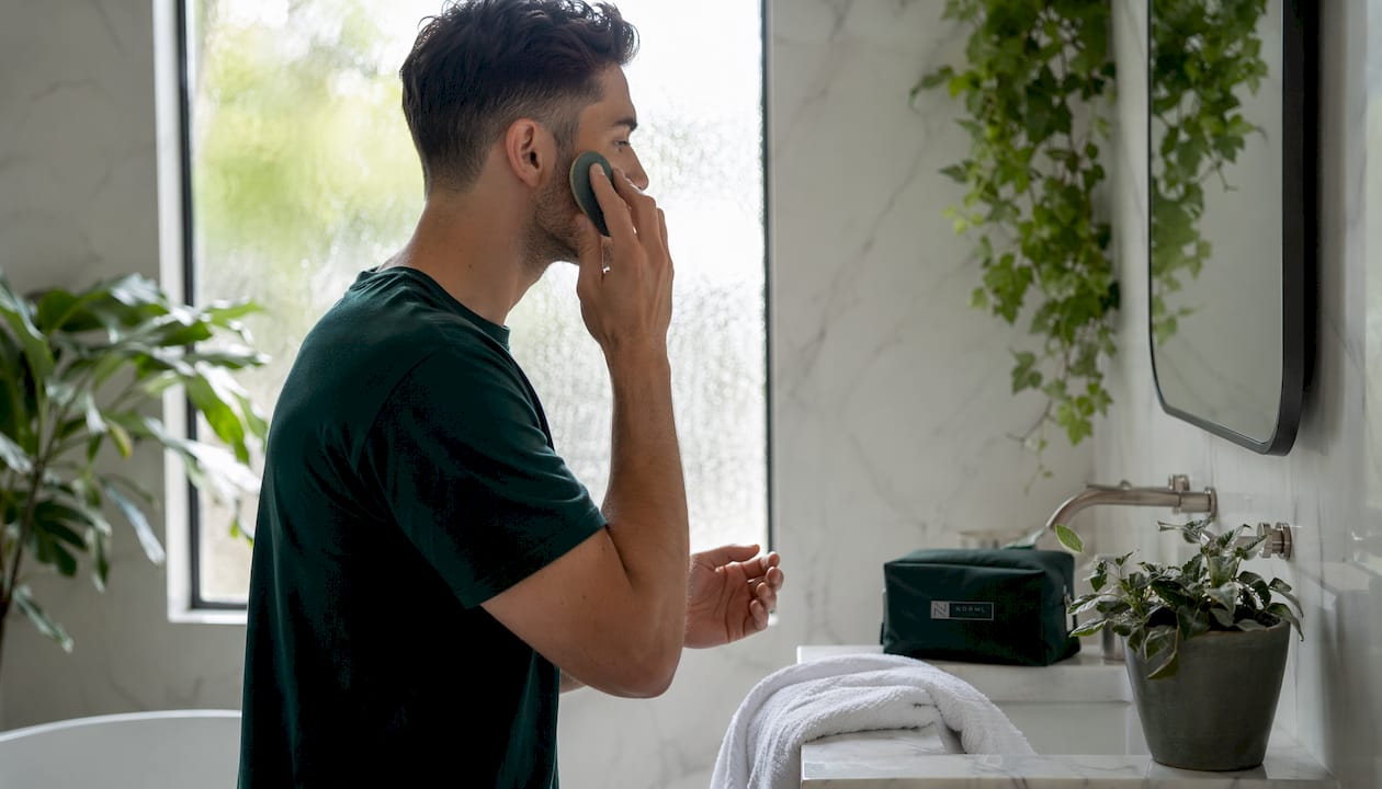 Male hands applying makeup with sponge