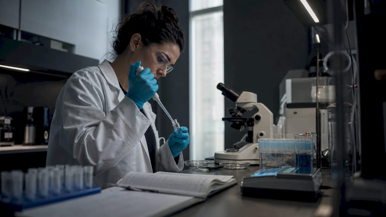 Neuroscientist pipetting peptide sample in lab