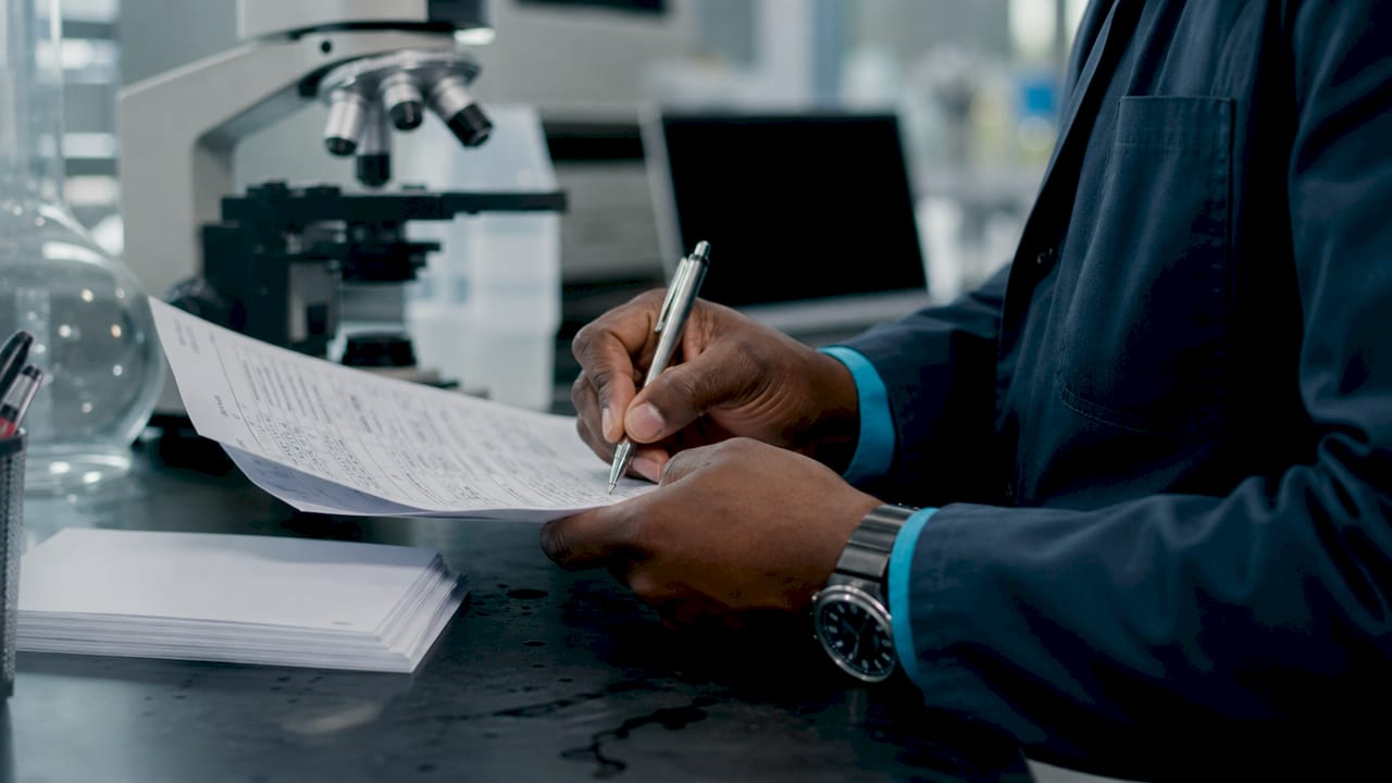 Hands reviewing peptide batch CoA paperwork