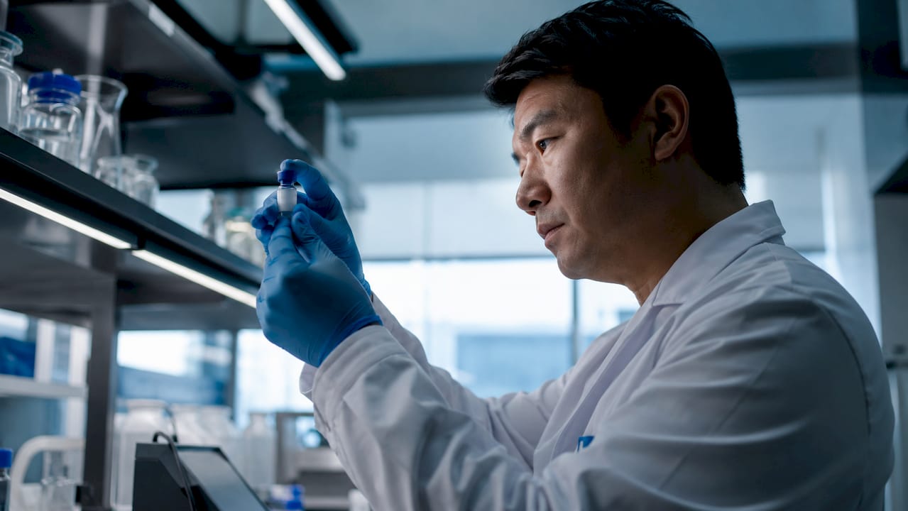 Lab technician inspecting peptide vial closely