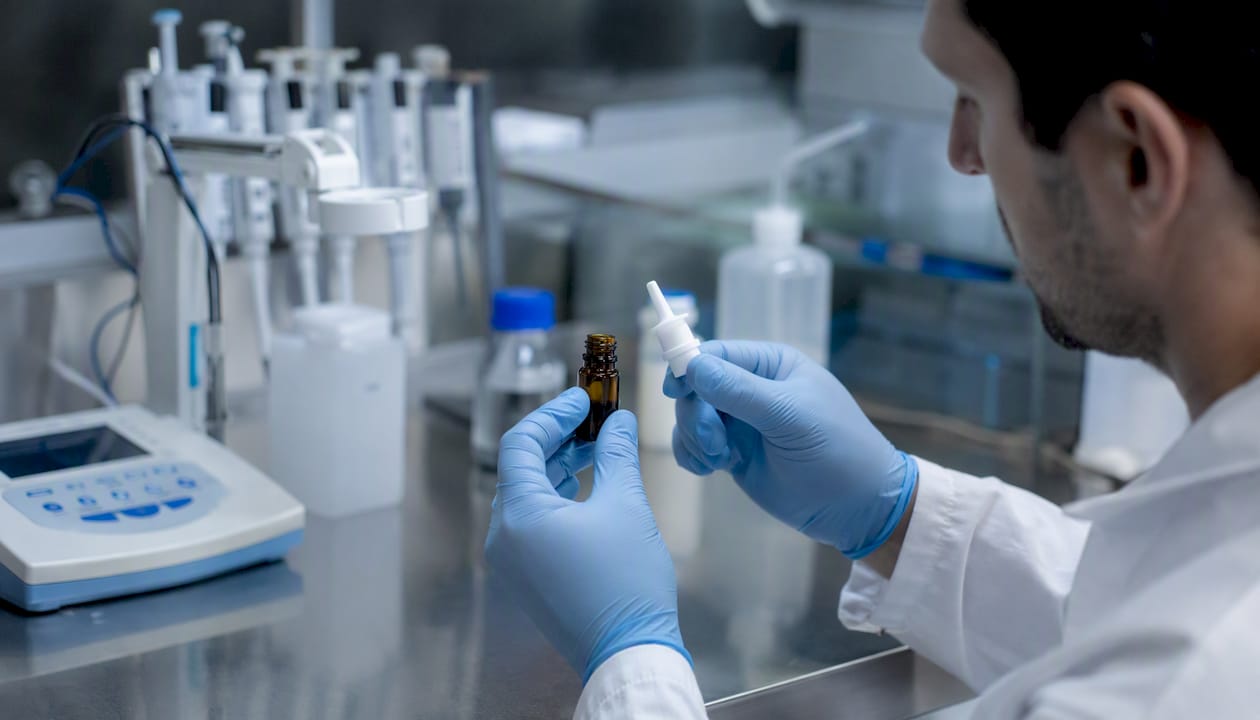 Hands preparing peptide nasal spray in lab