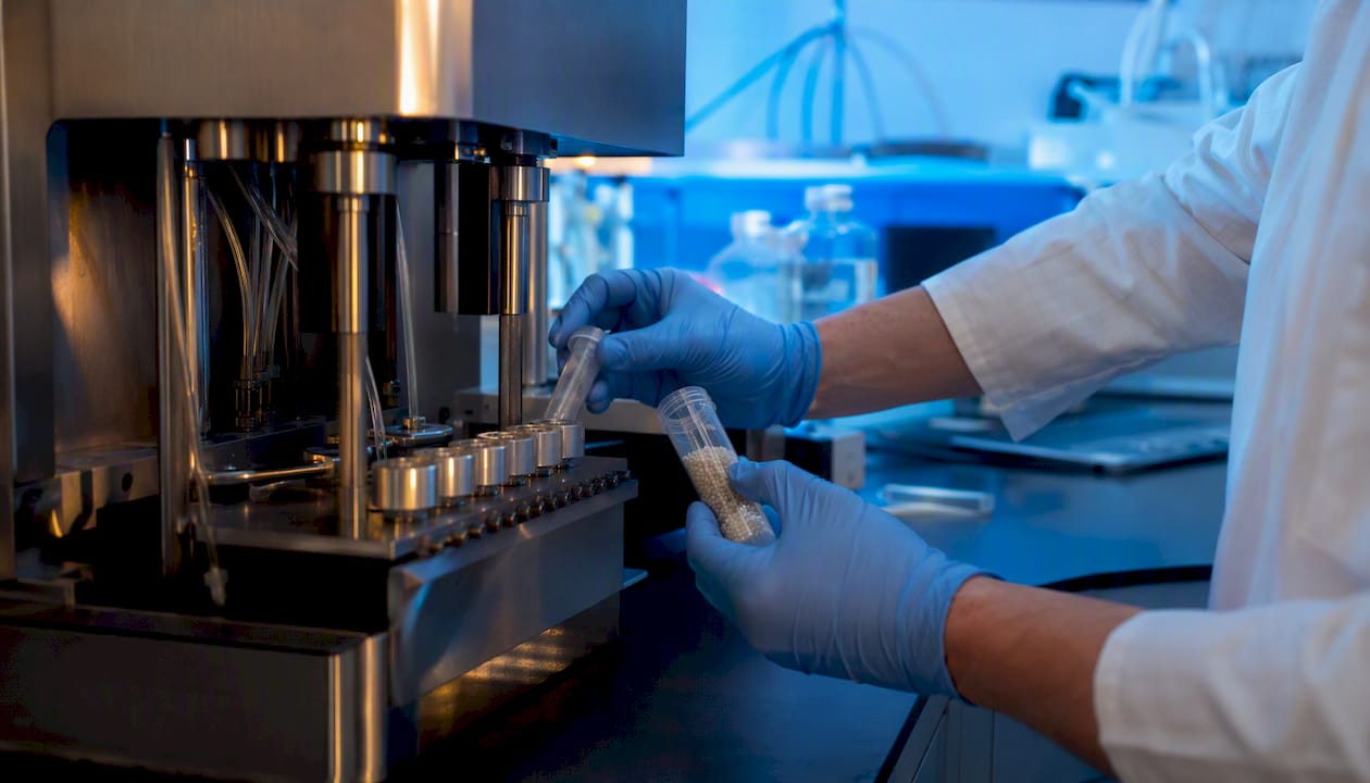 Technician loading resin beads for peptide synthesis