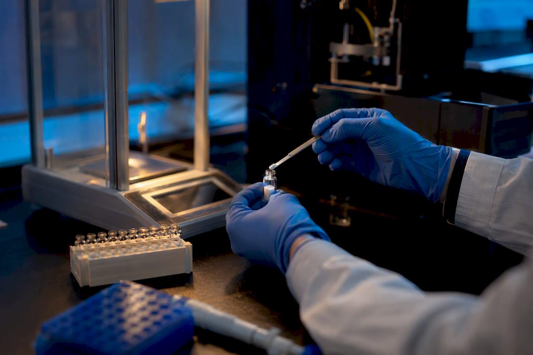 Gloved hands preparing peptide vial for LC-HRMS