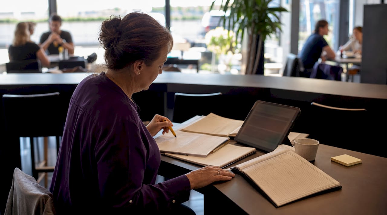 Small business owner reviewing manual bookkeeping papers