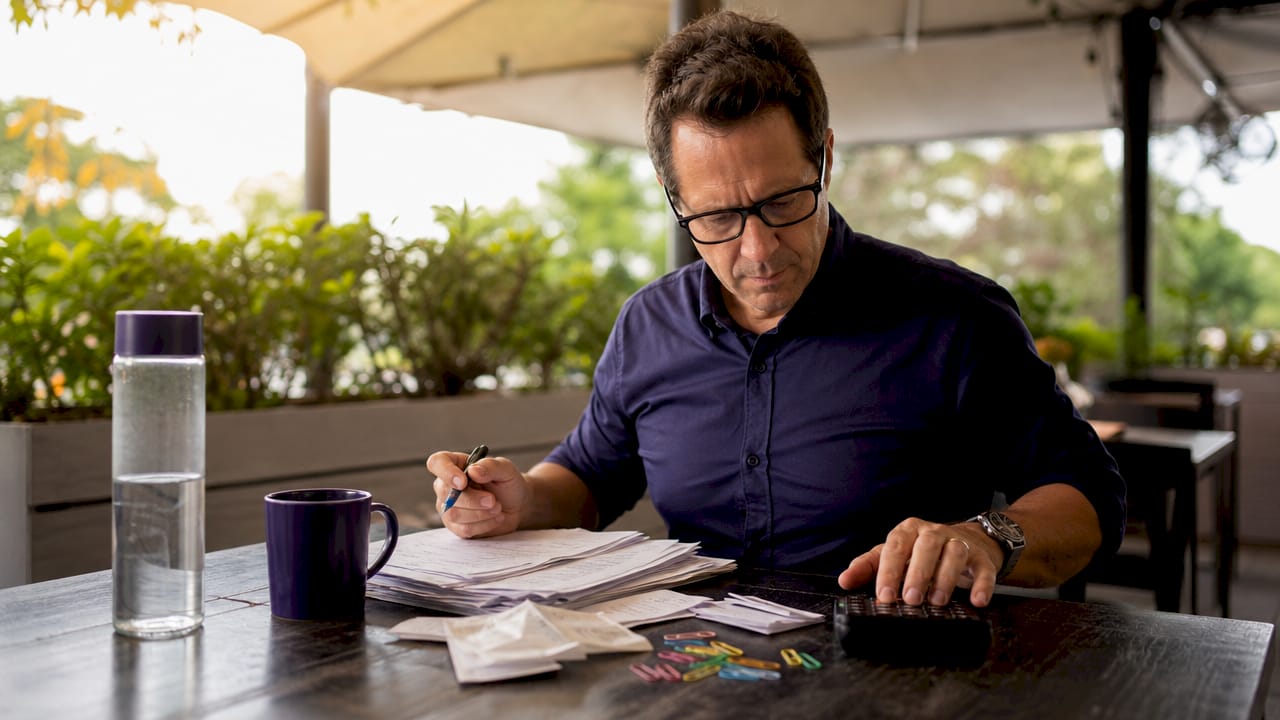 Hands calculating expenses with receipts