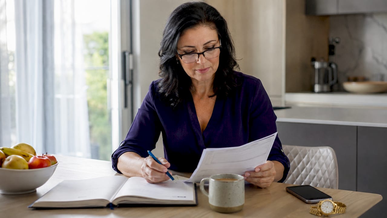 Woman reviewing quarterly tax documents at home office