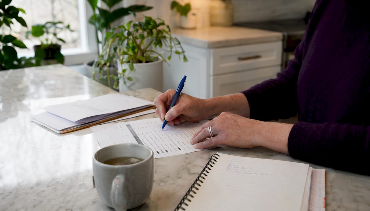 Hands marking tax deductions on checklist