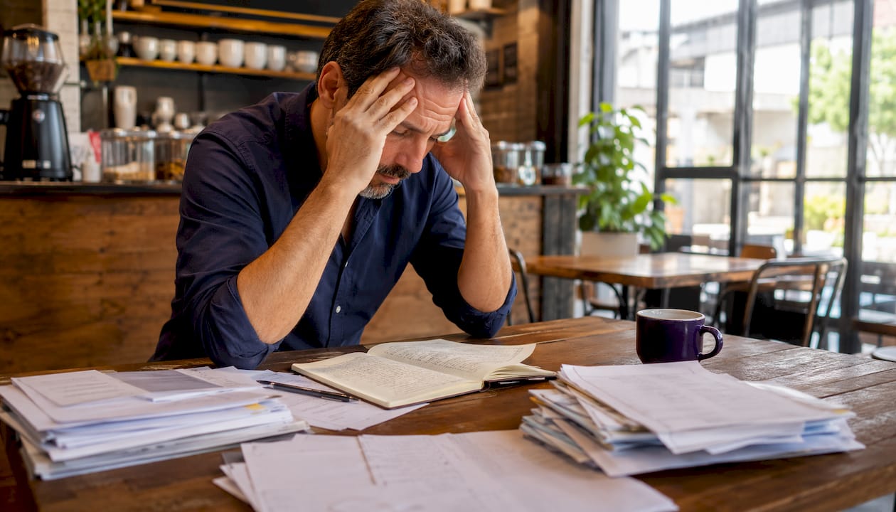 Stressed businessman with tax papers at kitchen table