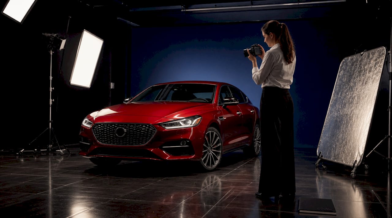 Photographer adjusting lighting in vehicle studio