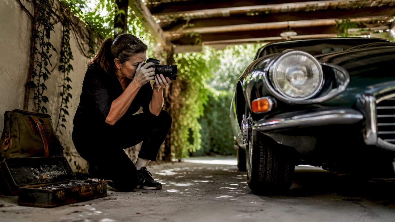 Photographer shooting classic car from overhead angle