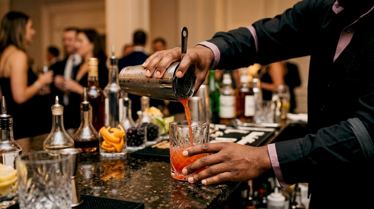 Hands mixing cocktail at conference bar station