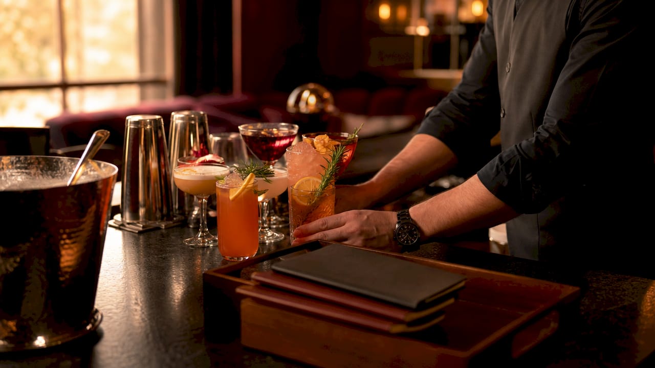 Bartender preparing signature cocktails and bar setup