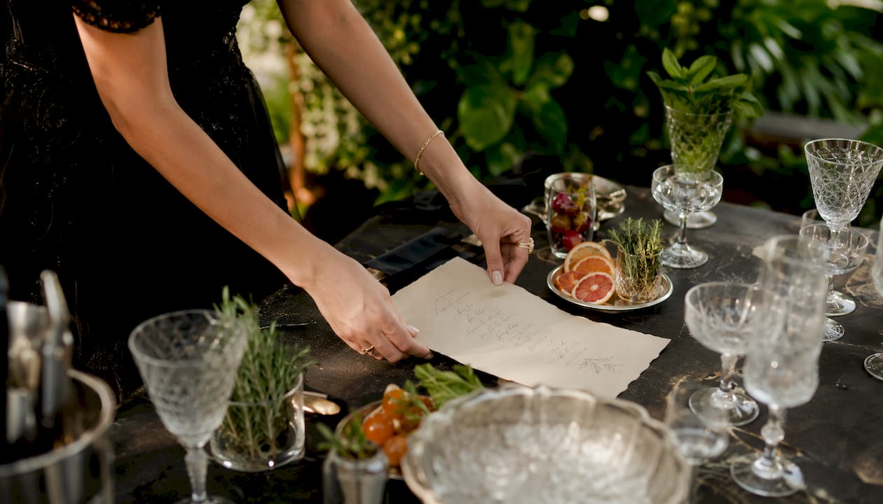 Hands holding personalized wedding cocktail menu indoors