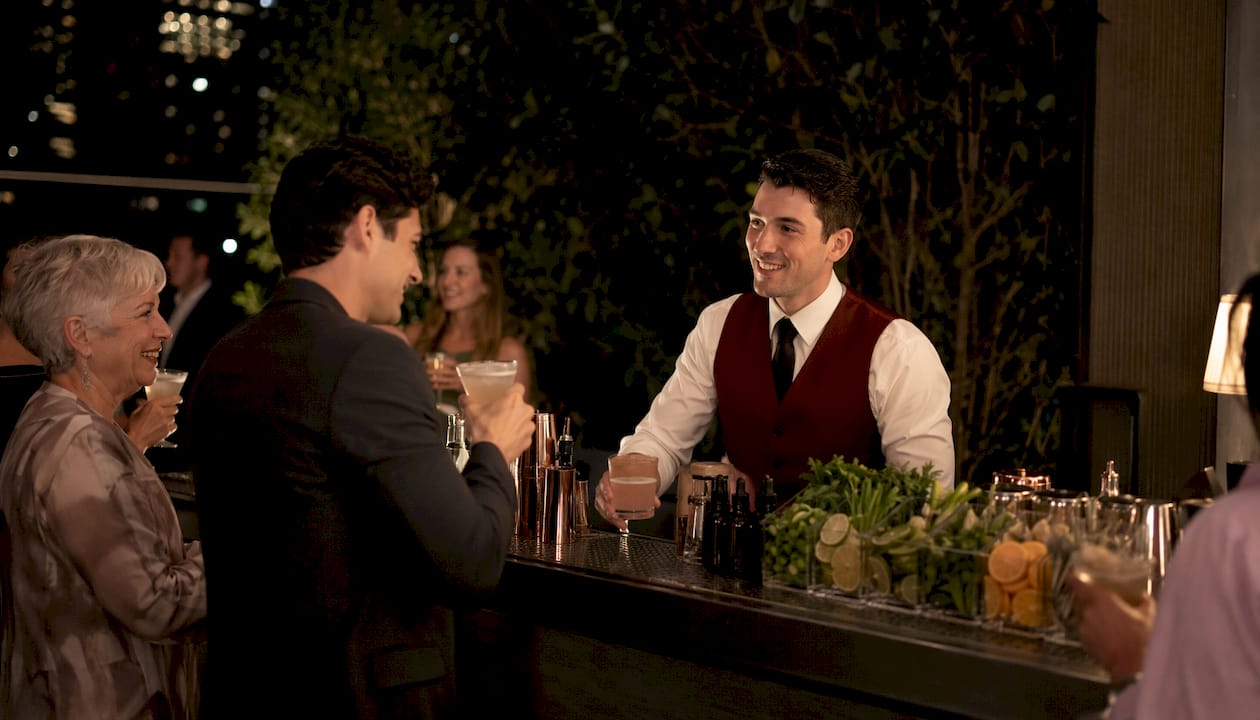 Guests sampling craft cocktails at mobile wedding bar