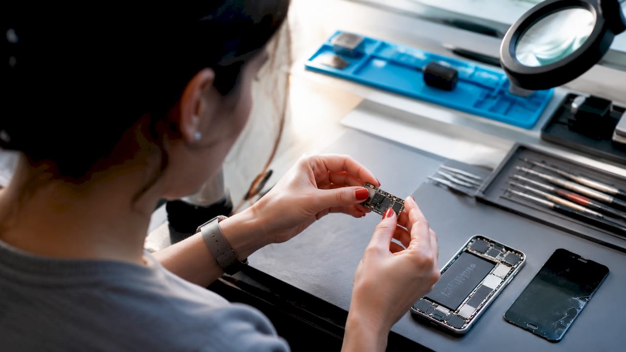 Hands repairing smartphone circuit board