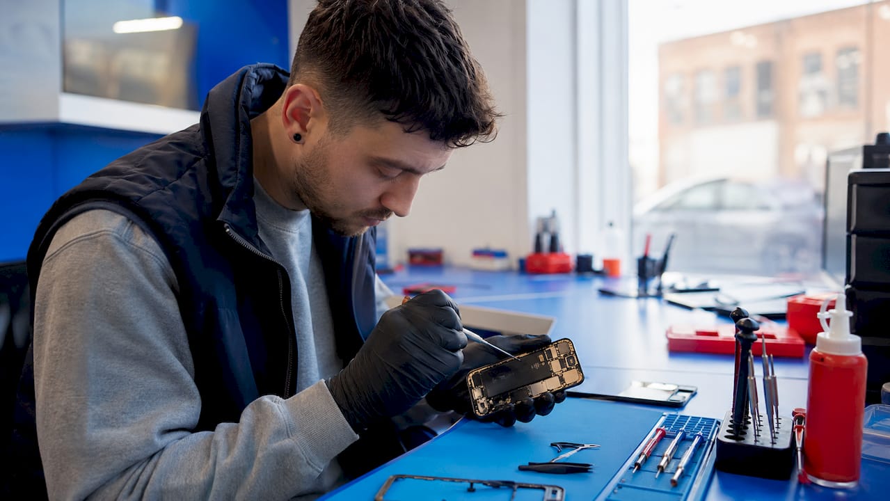 Technician examining iPhone hardware internally