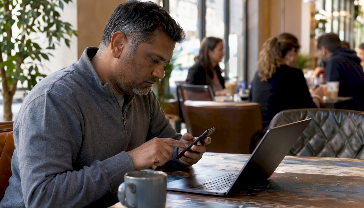 Man testing iPhone vibration at coworking desk