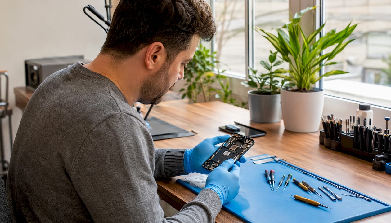 Technician inspecting iPhone internal wireless charging parts