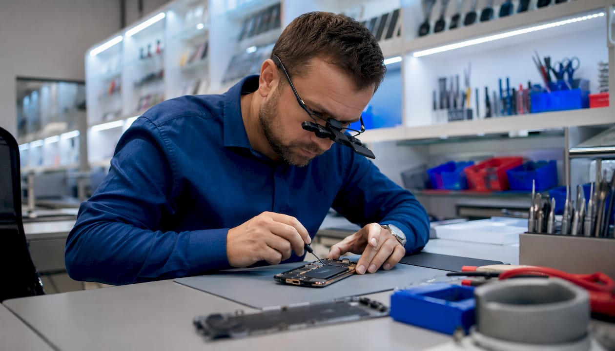 Technician repairing iPhone at professional shop
