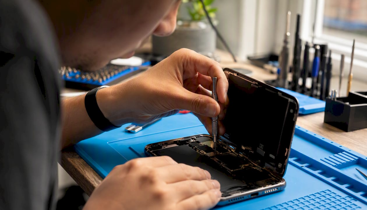 Hands inspecting iPhone internal connectors
