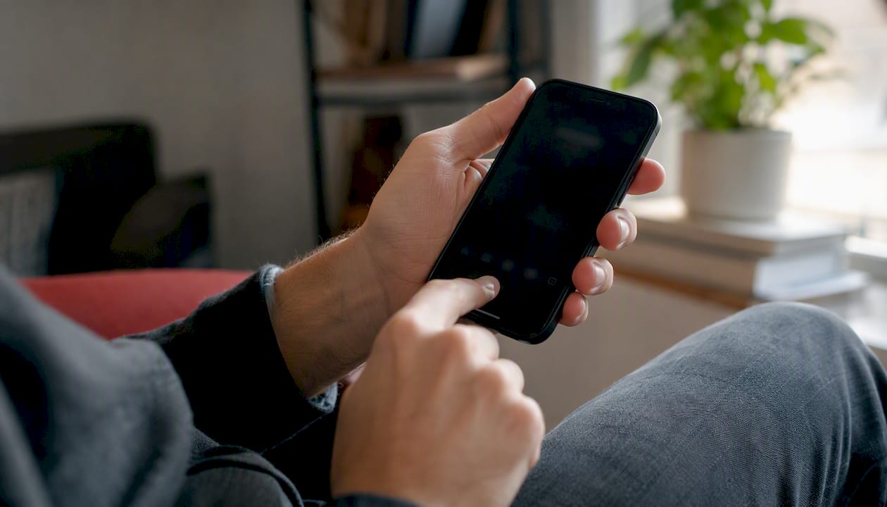 Hands testing iPhone microphone with phone held