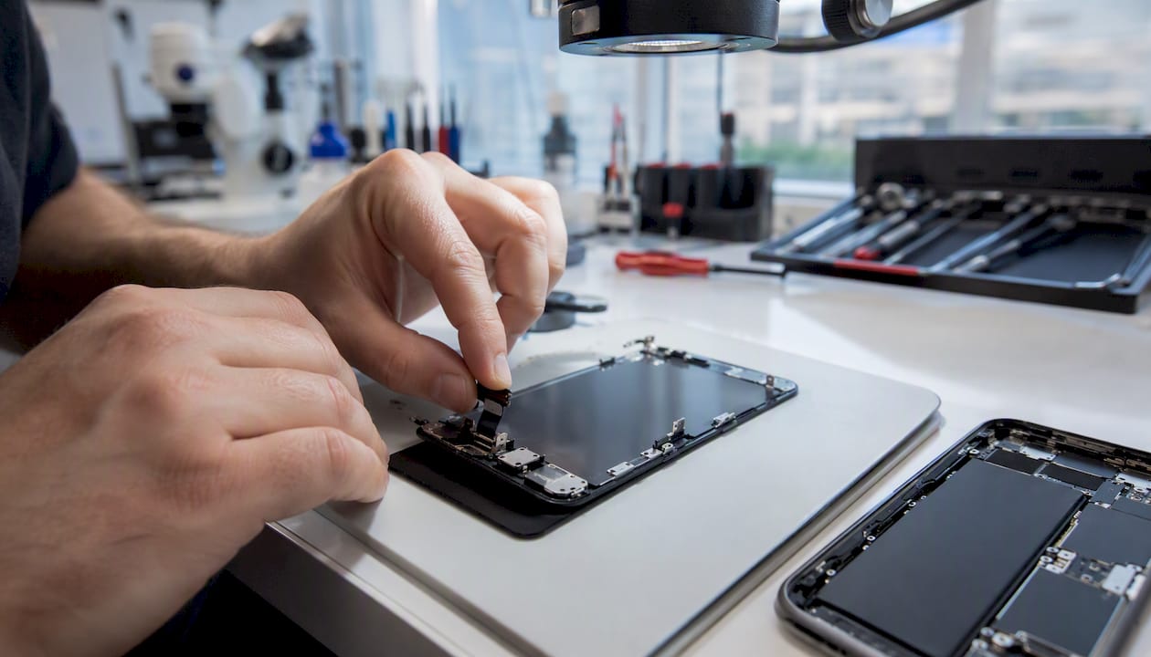 Hands inspecting smartphone display connector cable